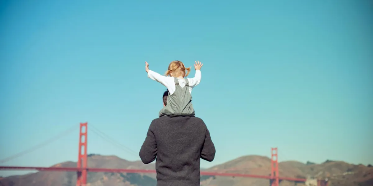 Girl on father's shoulders at the Golden Gate Bridge in San Francisco, California