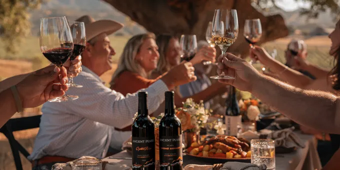 Group of people seated at table drinking wine at Santa Margarita Ranch, in California